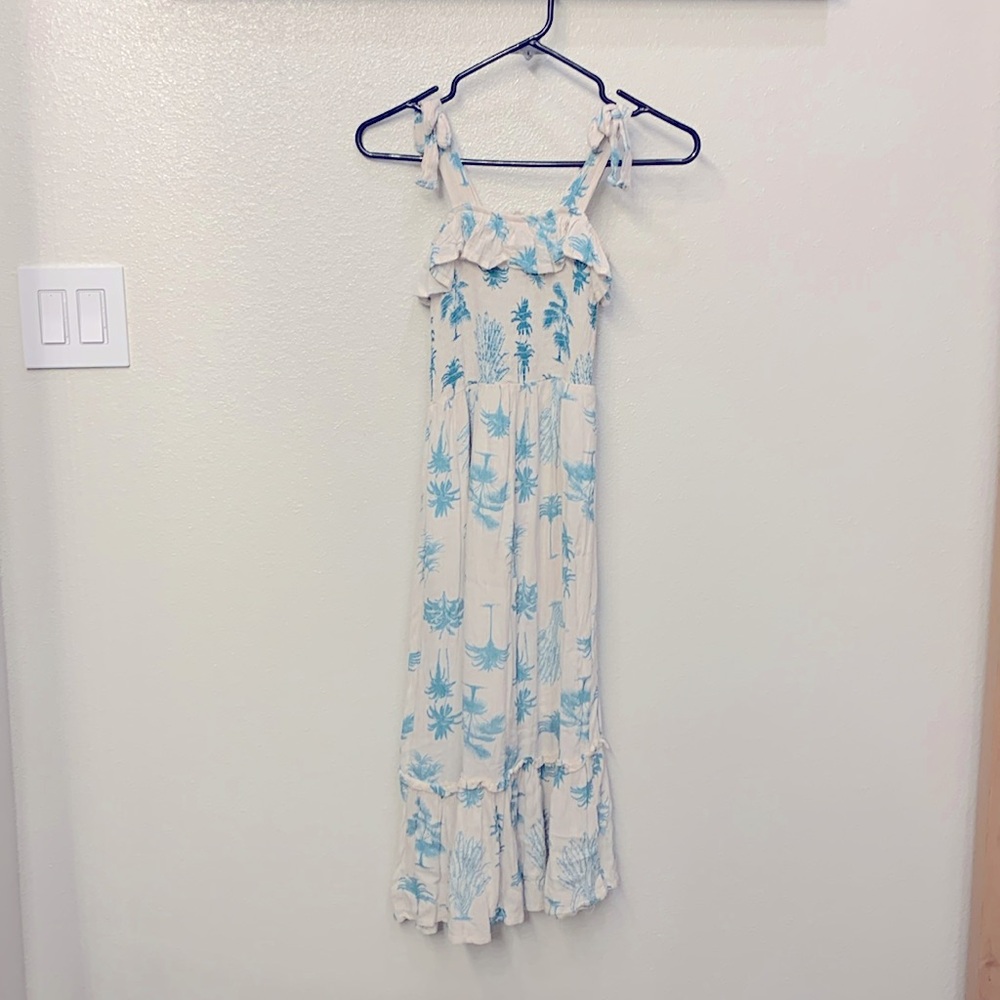 This a fun, summer dress with a palm tree pattern and a flowy bottom
